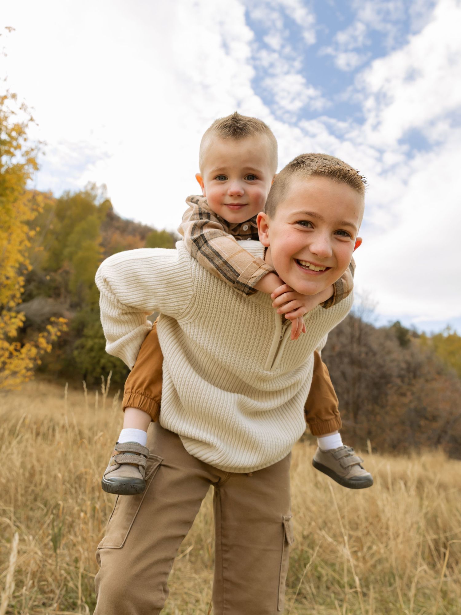 Joyful piggyback ride in an autumn field with fall foliage.