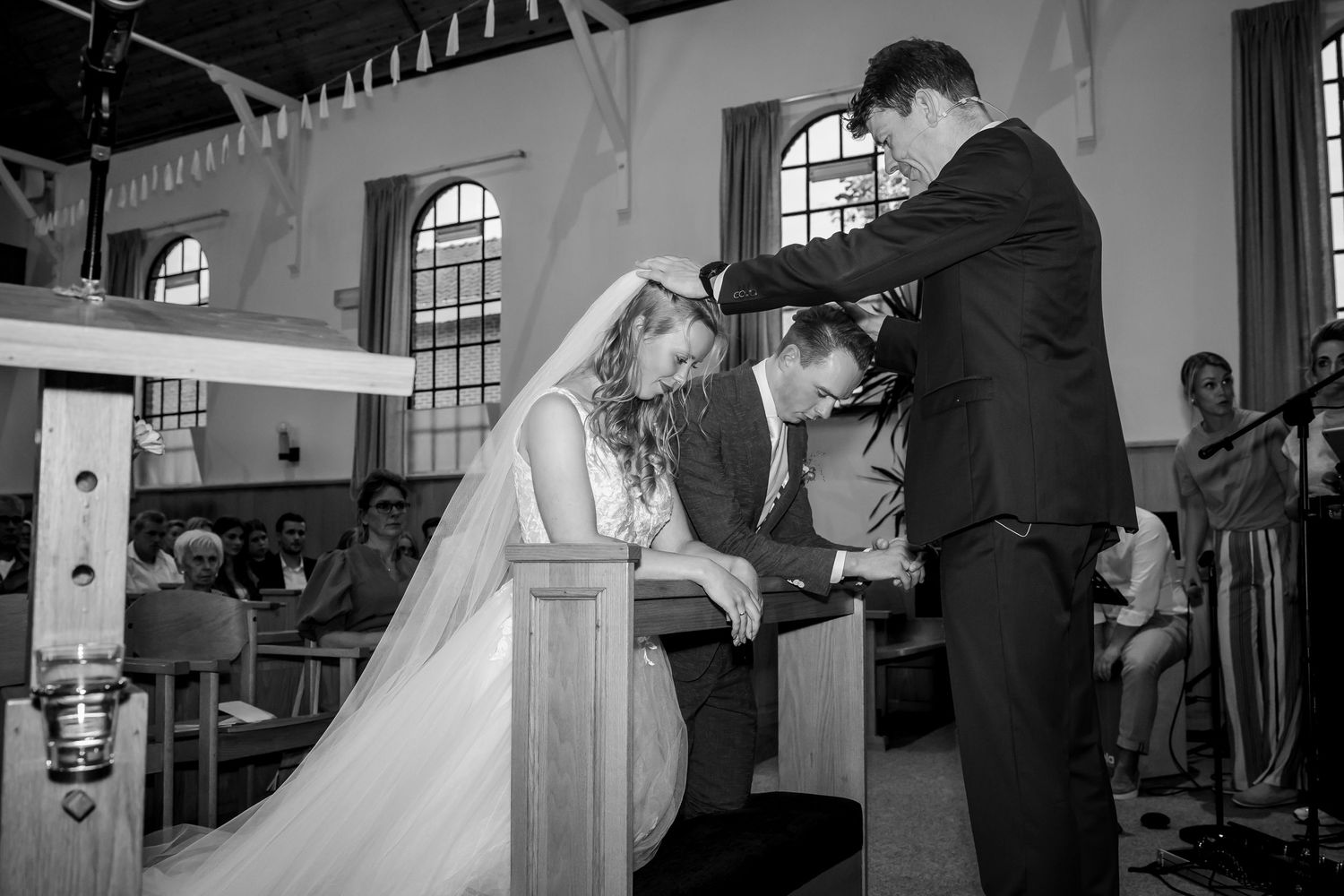 Een zwart-witfoto van een huwelijksceremonie in een historische kerk.
