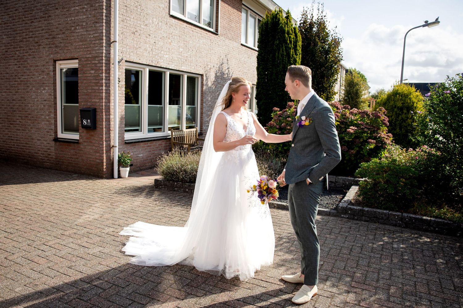 bruidspaar heeft elkaar voor het eerst gezien in hun trouwkleding en zij is blij met zijn pak