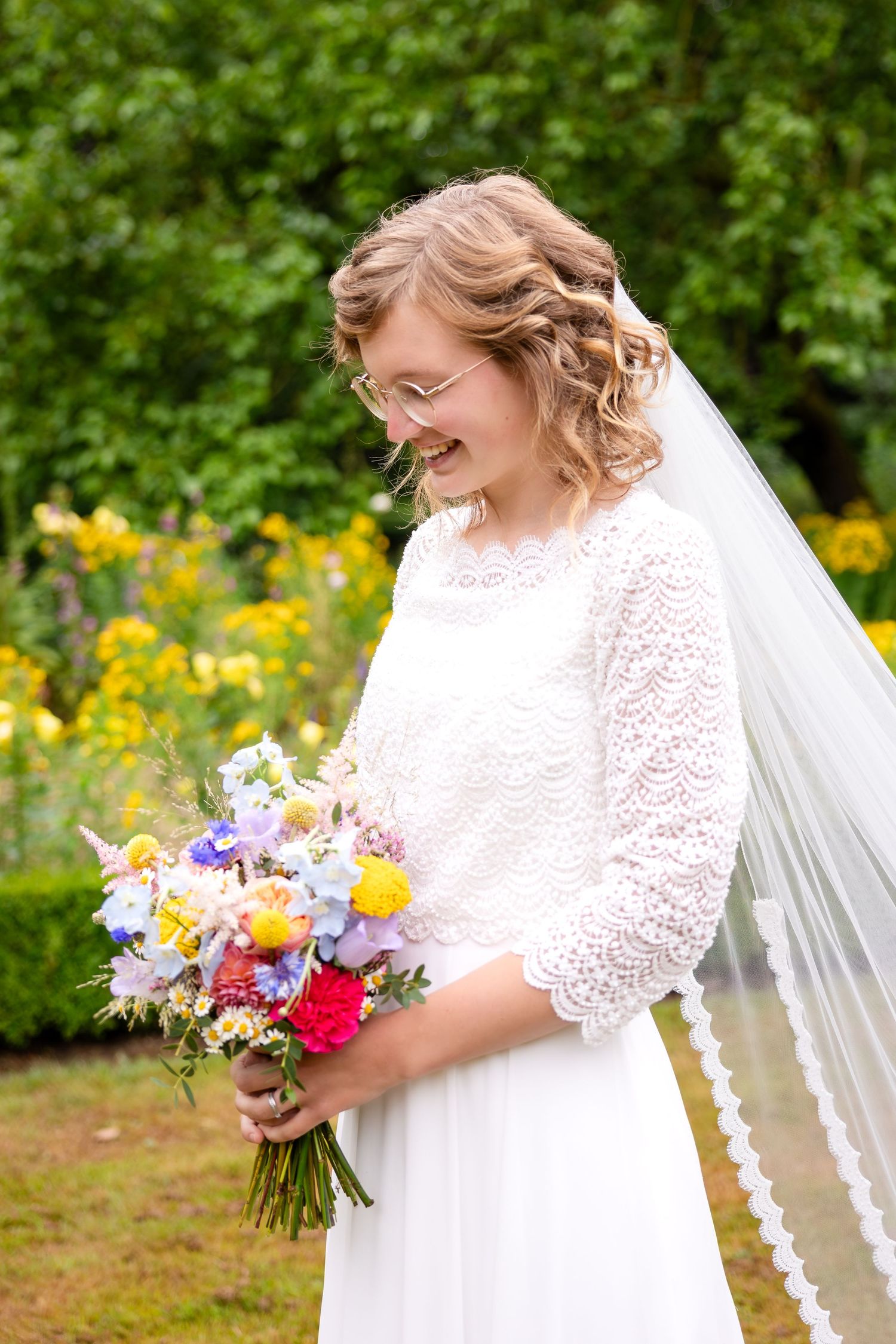 A bridal portrait with colorful wildflower bouquet against garden backdrop.
