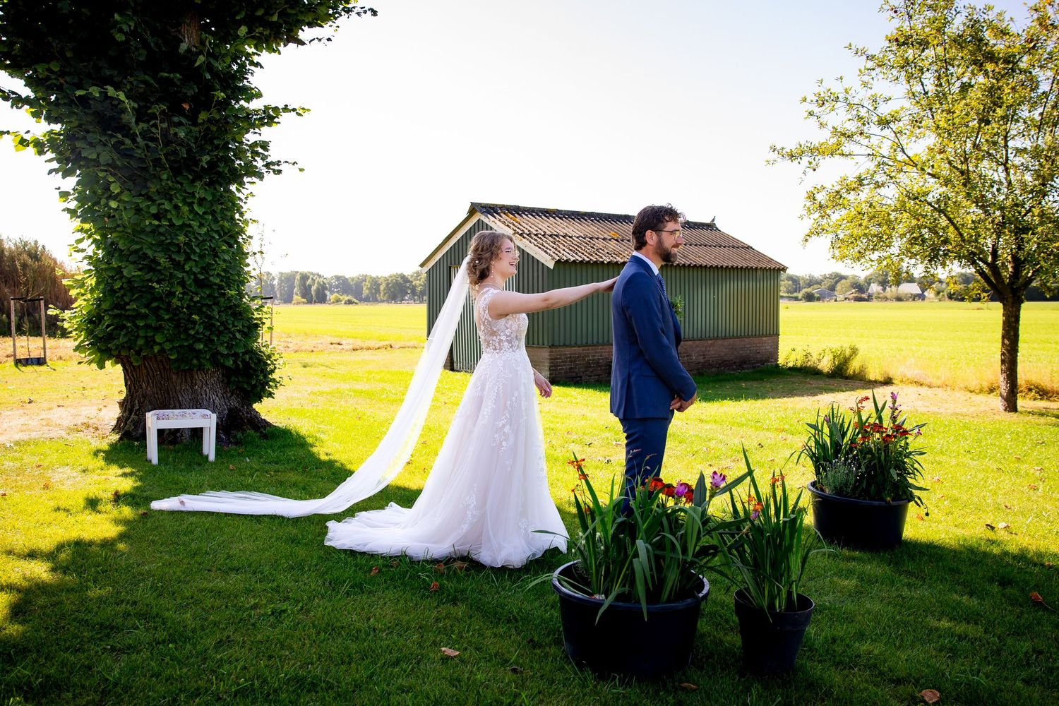 Sunlit garden wedding scene with couple sharing their first look.