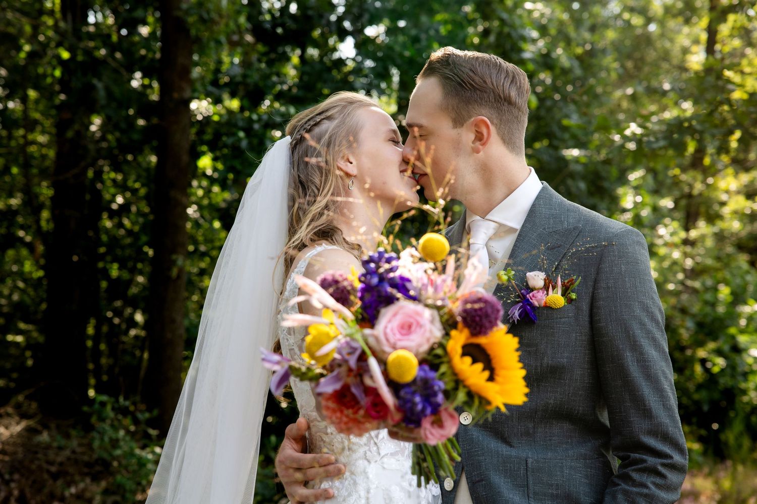 Een romantische trouwfotoserie van een stel dat intieme momenten deelt in een zonnige, bosrijke omgeving.
