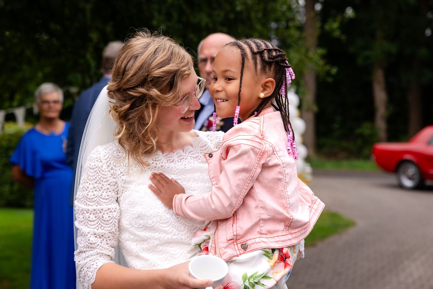 Wedding celebration in a garden setting with guests wearing colorful summer attire.