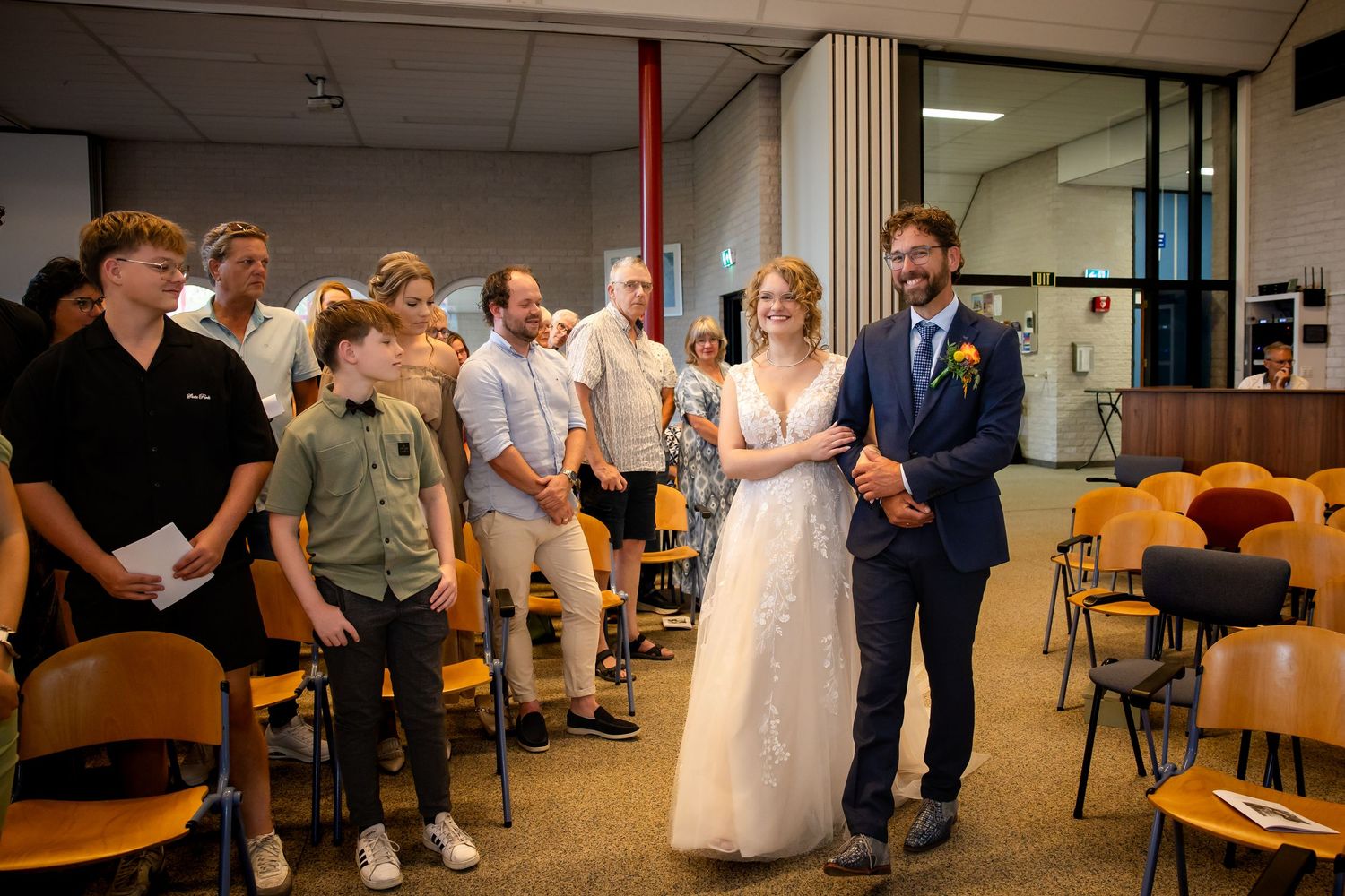 Wedding celebration with guests dancing and mingling in a casual indoor reception space.