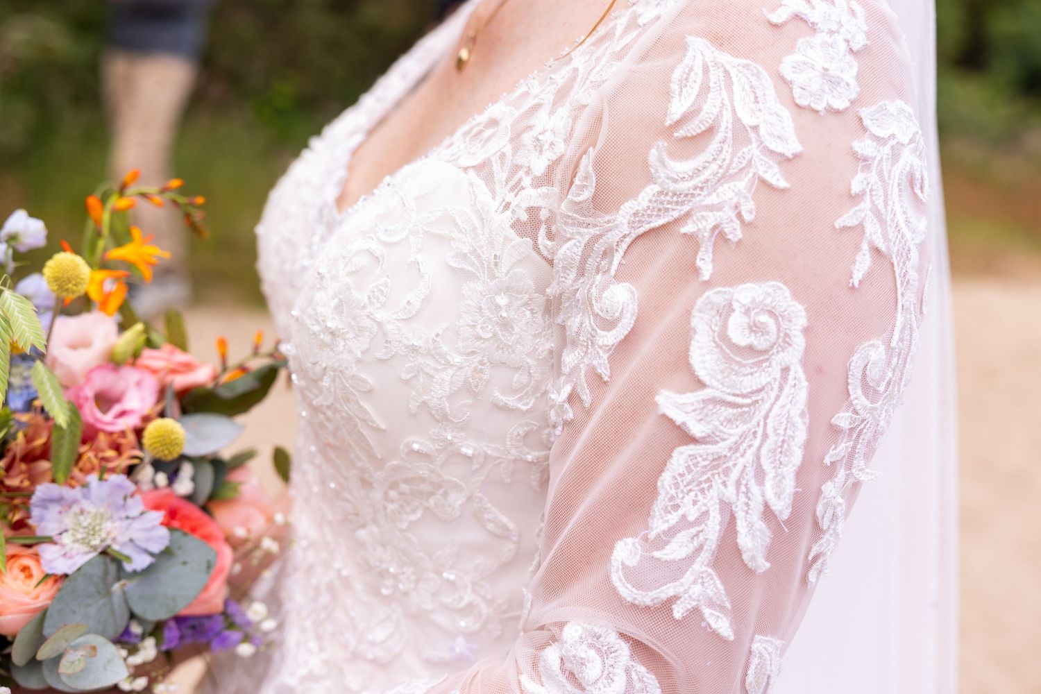 Close-up detail of delicate white lace pattern on a wedding dress.