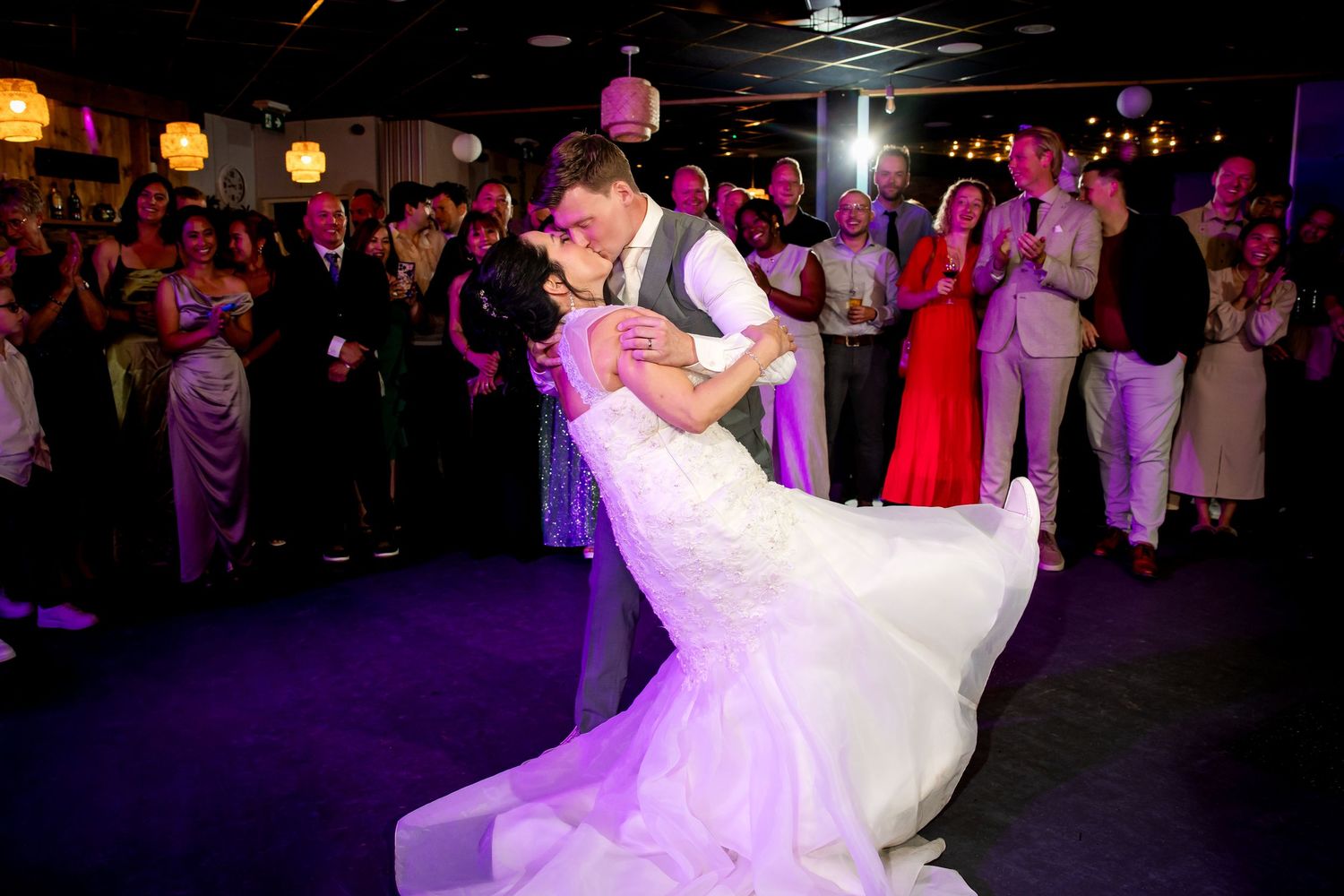 Bruidspaar danst hun openingsdans van hun bruiloft met familie en vrienden om hen heen