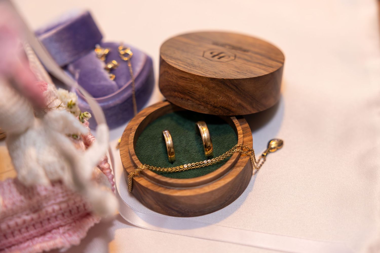 Delicate jewelry pieces displayed in wooden boxes on a table.
