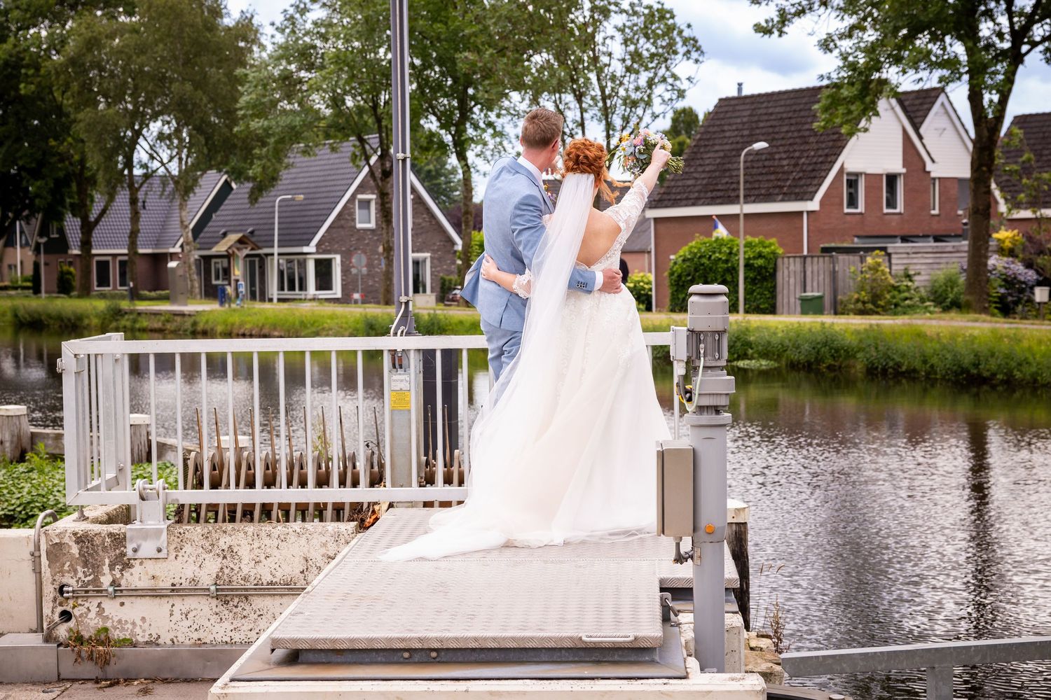 Wedding portraits taken along waterfront with Dutch houses in background.