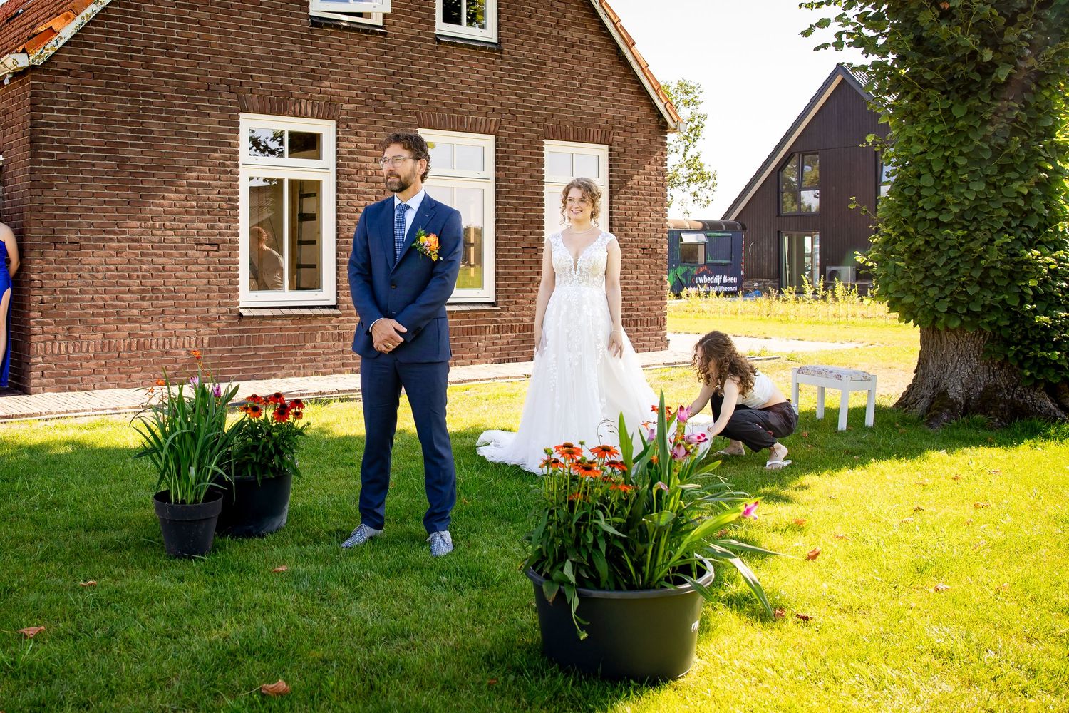 Outdoor wedding first look moment in front of a brick farmhouse.