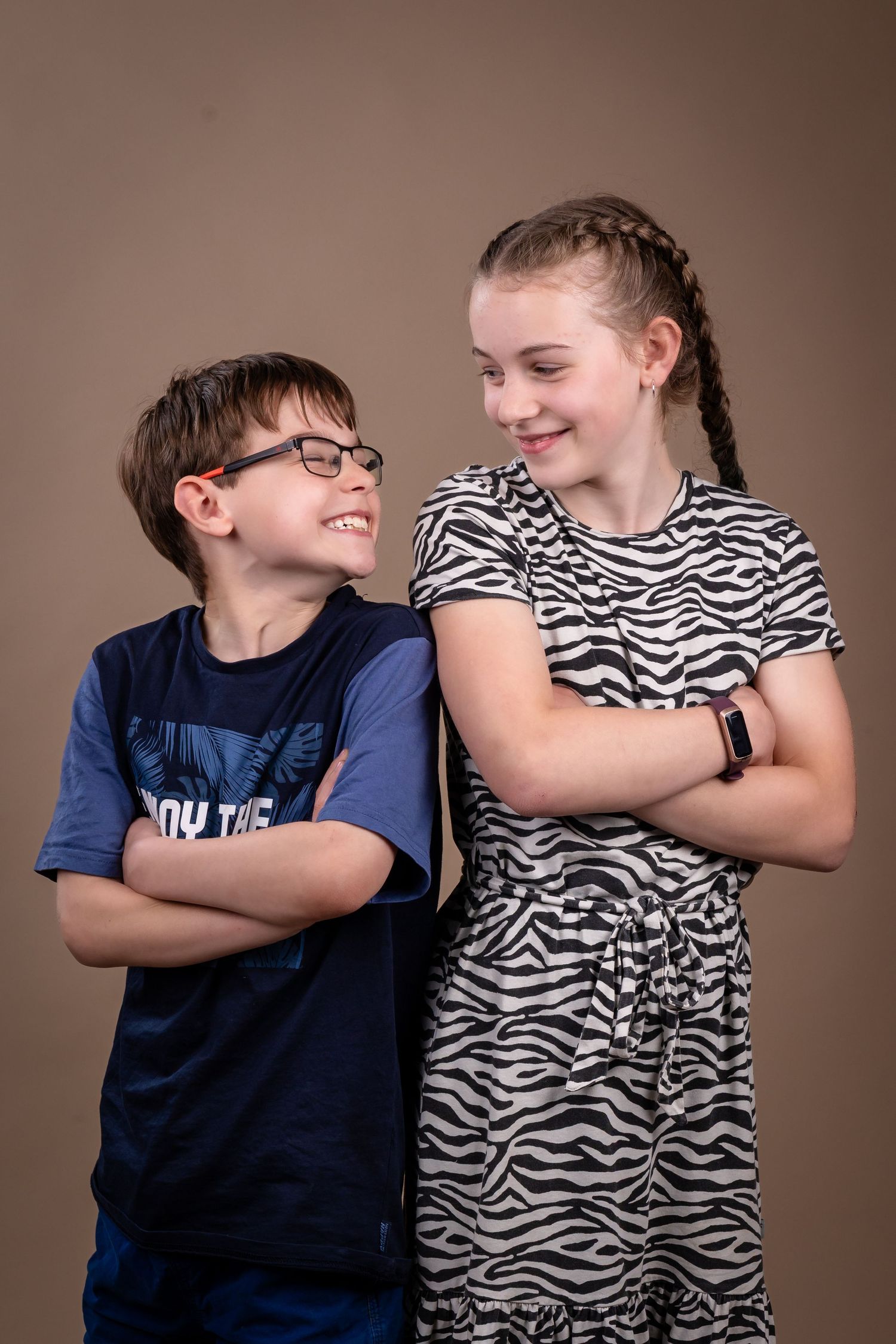 A series of candid photos showing two young people in casual clothing sharing playful moments against a brown backdrop.