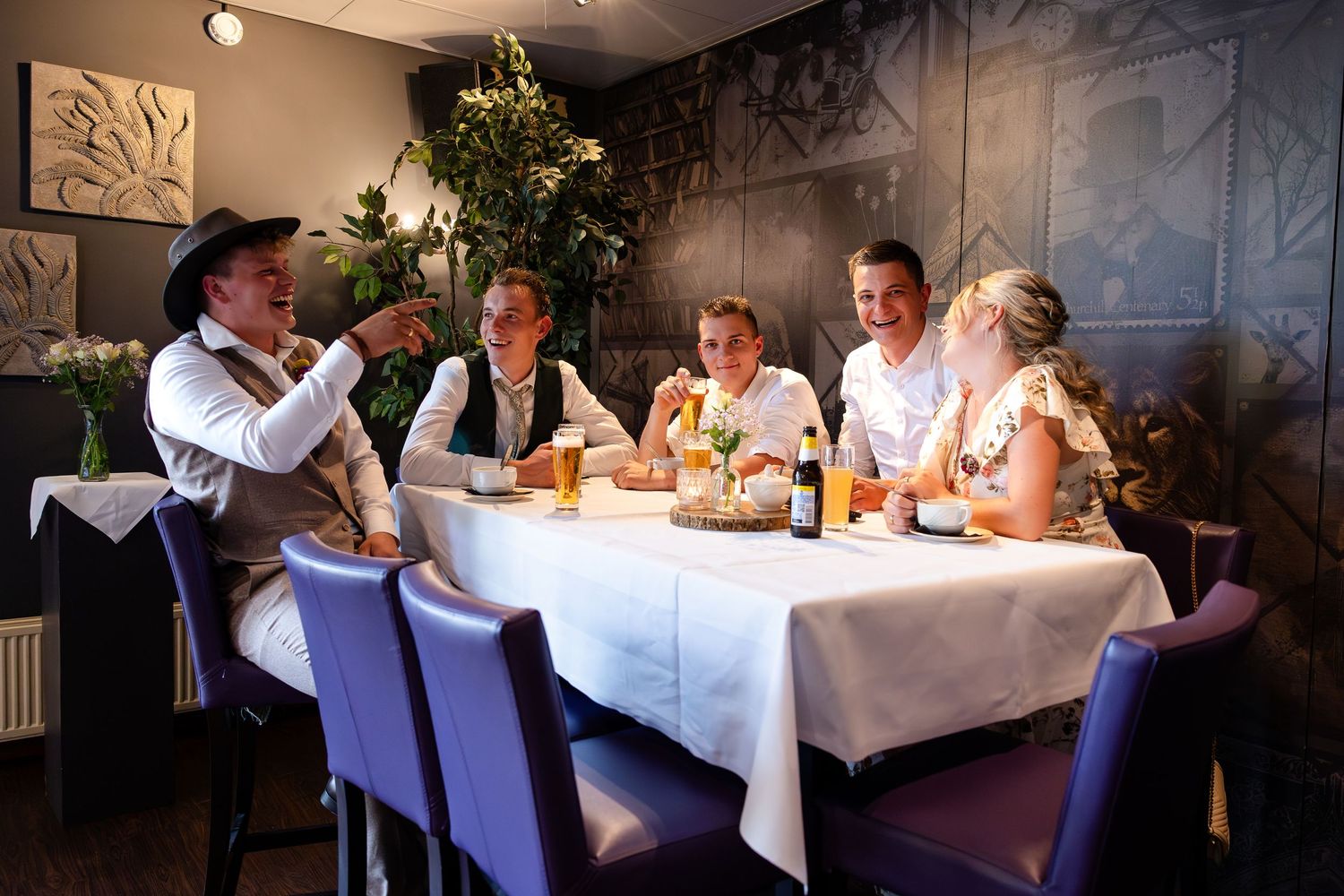 Wedding reception dinner table with guests seated in an elegant indoor venue.