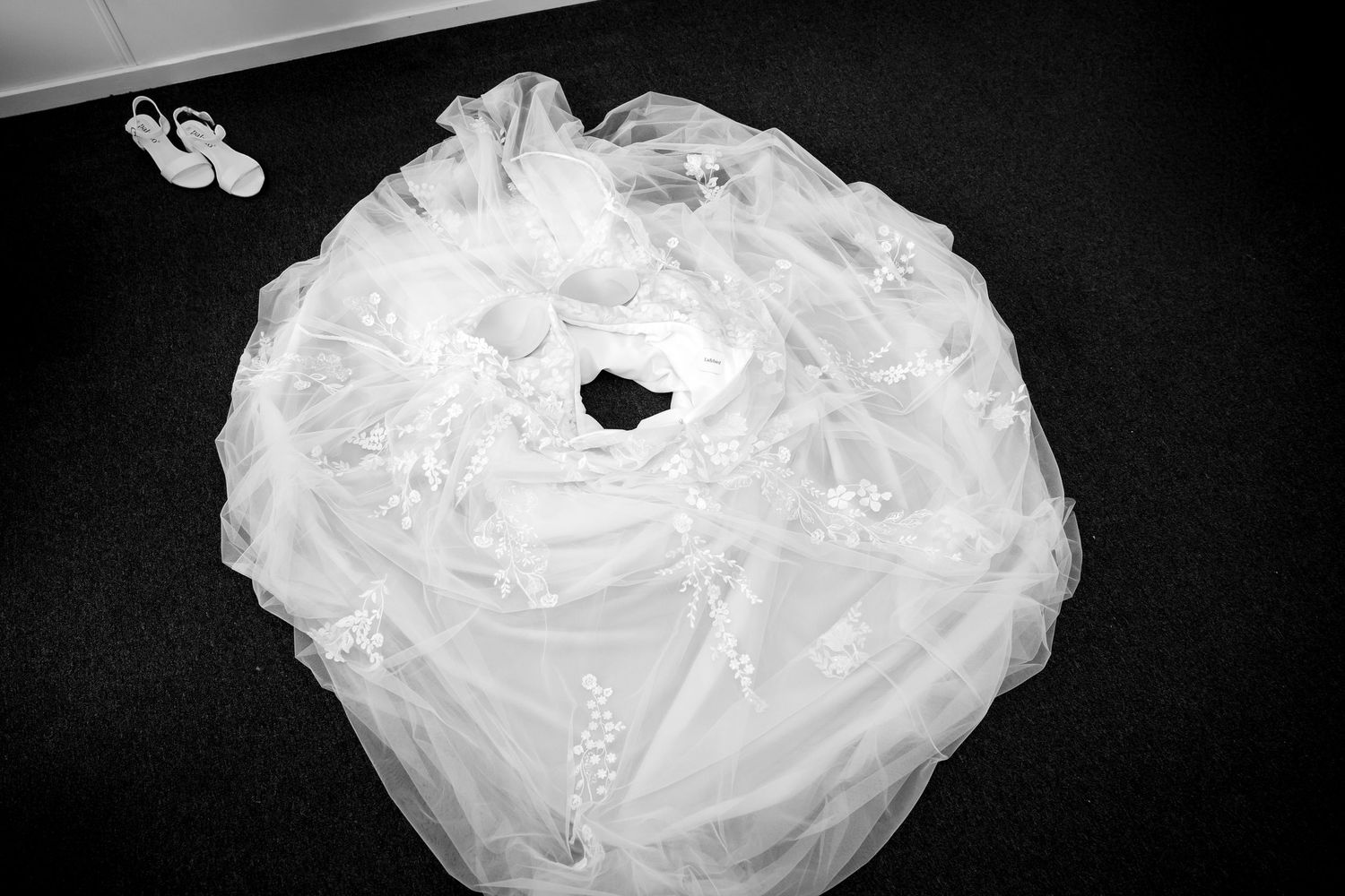 Black and white detail shot of flowing white wedding dress fabric.