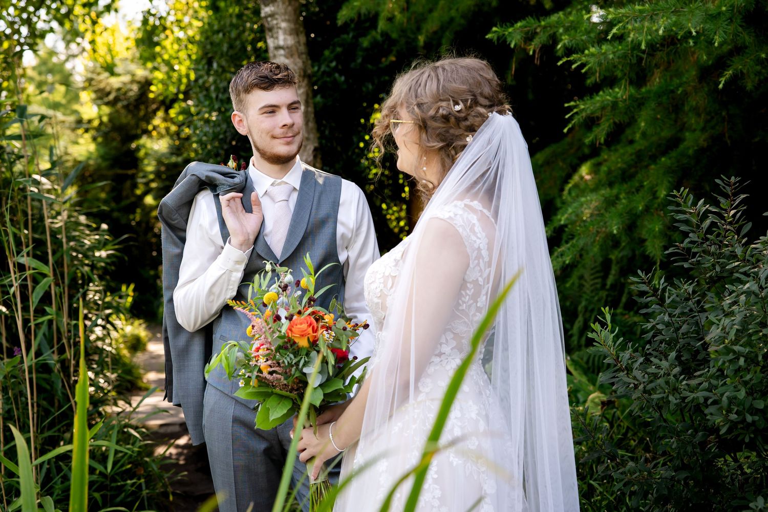 Wedding couple sharing intimate moments in a vibrant garden setting.