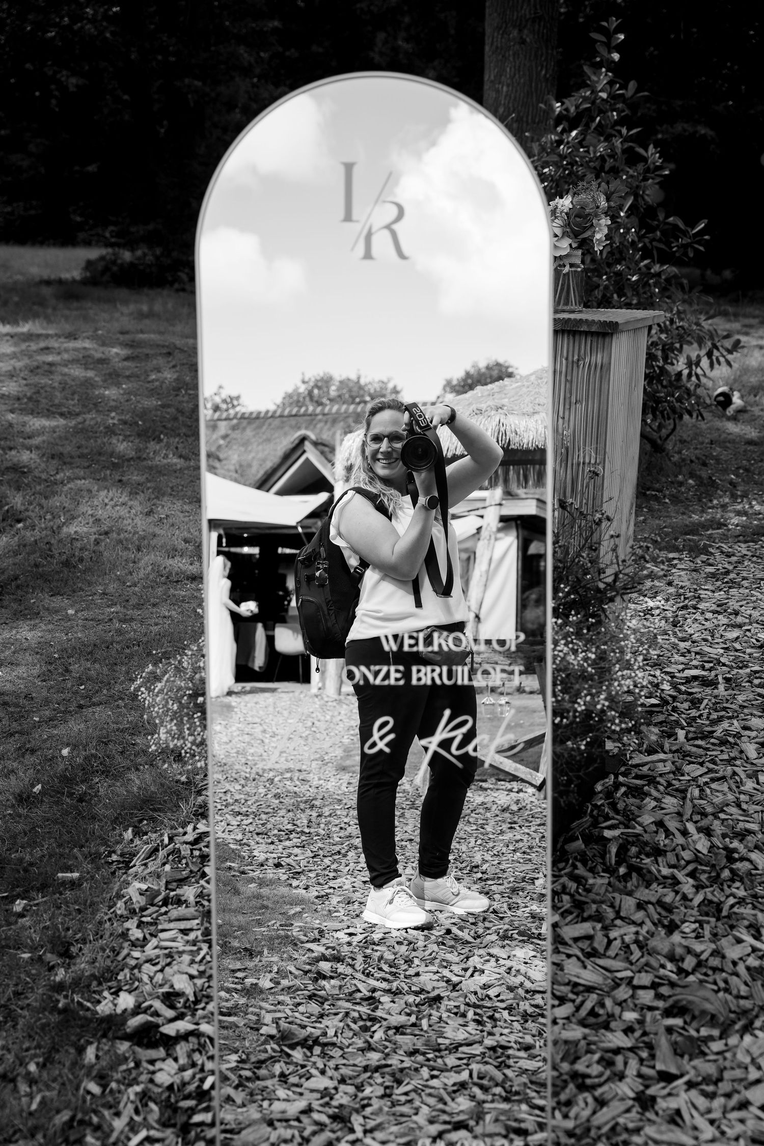 Creatieve spiegelreflectiefoto van een monochrome bruiloftstafereel met decoratieve letters.