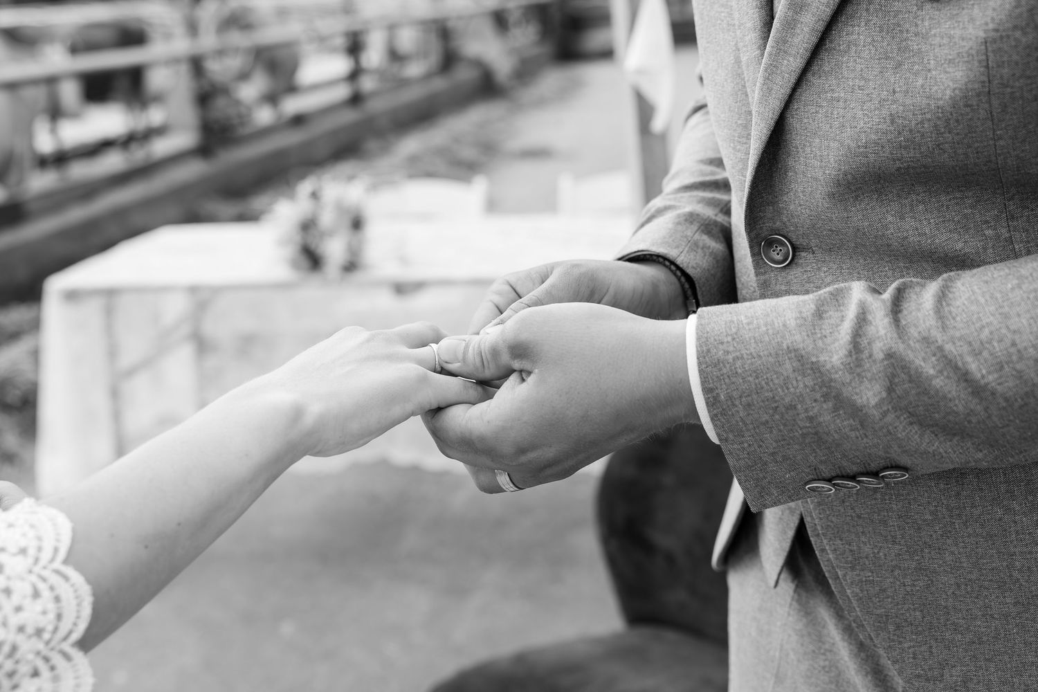 Close-up of hands exchanging wedding rings during a ceremony.