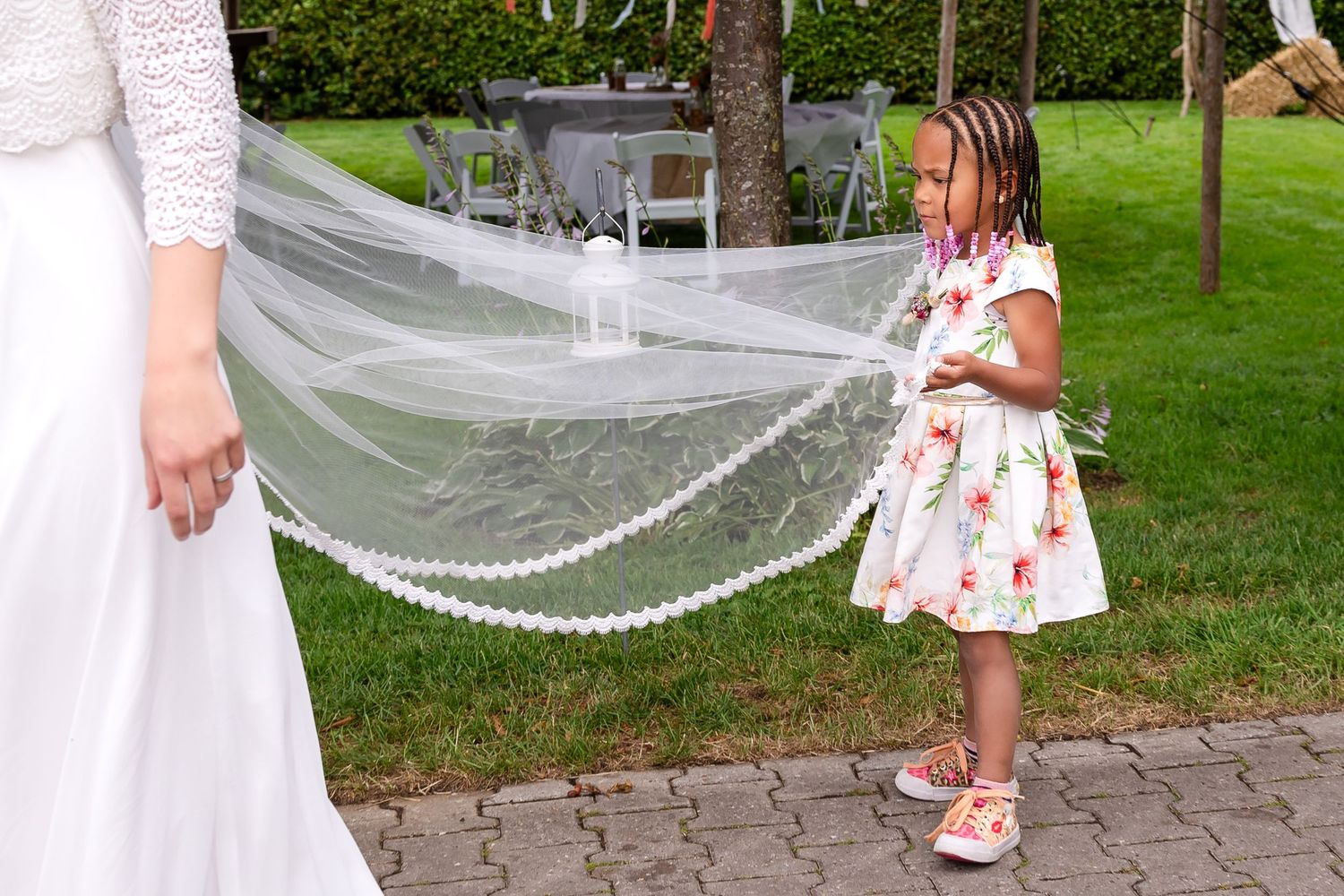 Wedding celebration in a garden with white decorations and flowing veils.