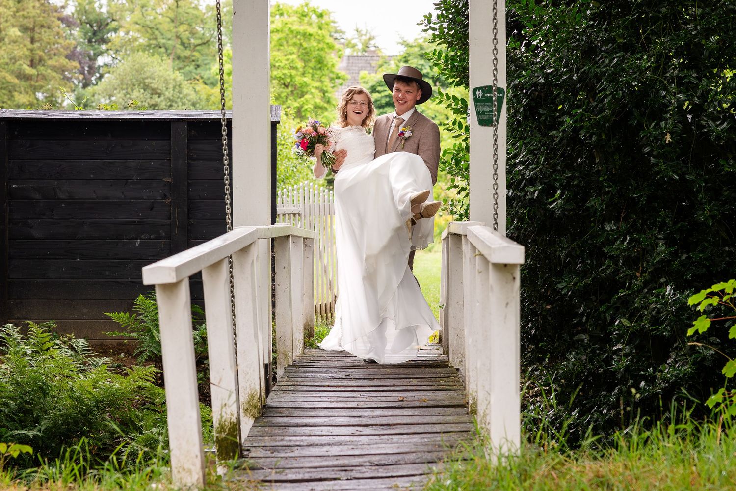 A wedding ceremony setup with white columns and greenery creating an elegant outdoor aisle.