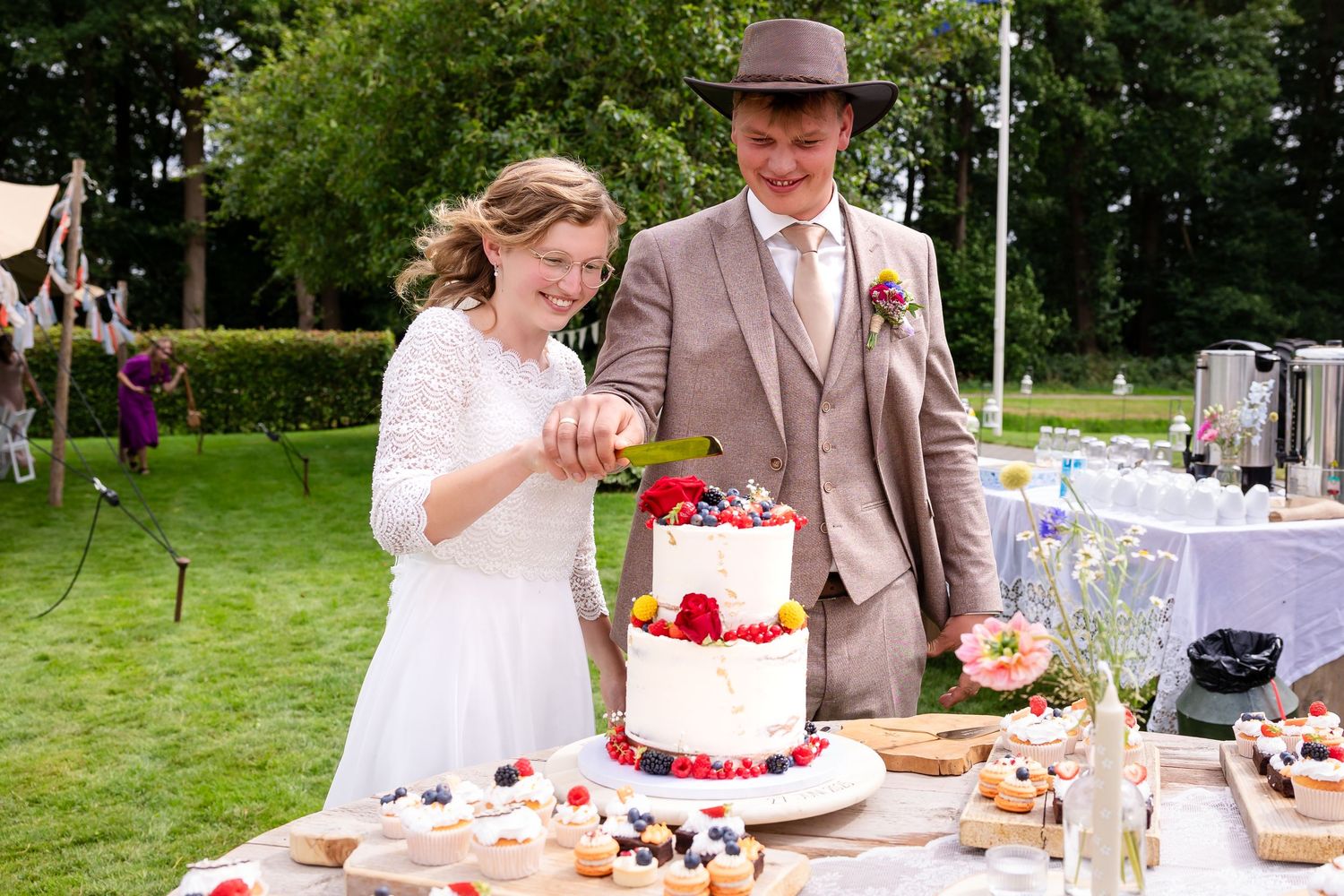 Wedding couple cutting their cake at an outdoor garden reception.