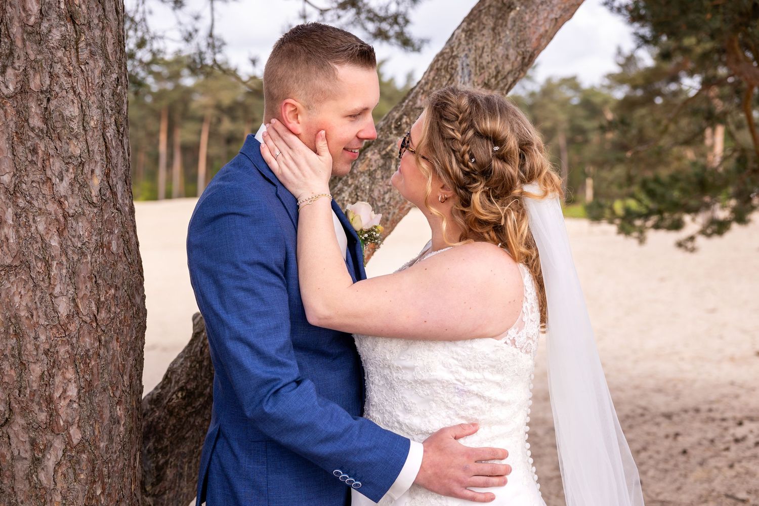 Intieme trouwportretten tegen een achtergrond van rustieke dennenbomen.