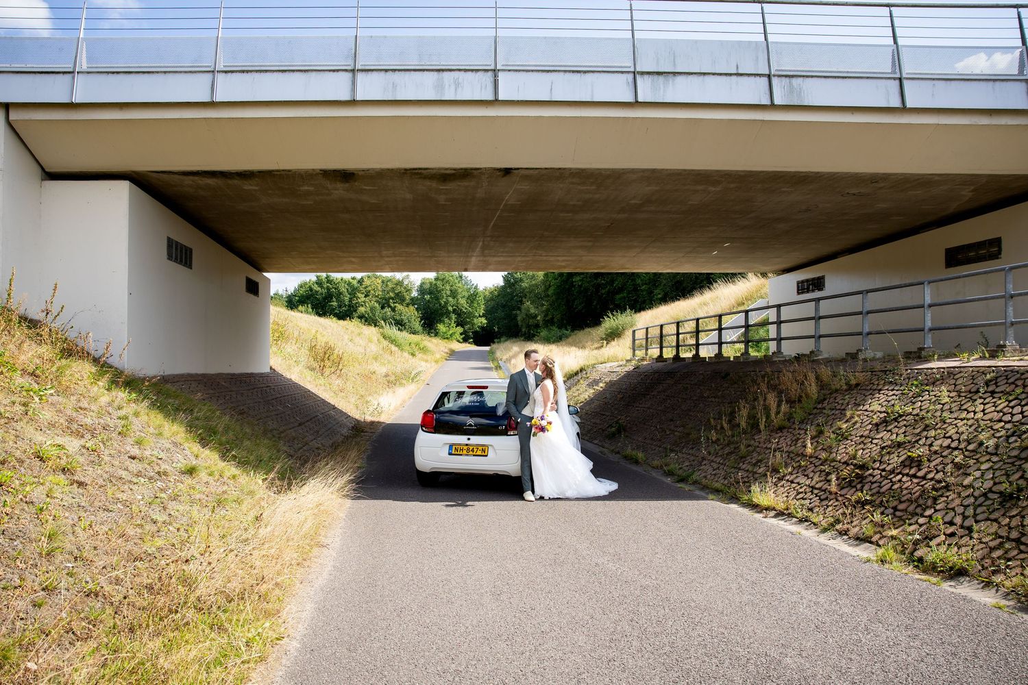 Breed panoramisch uitzicht op een betonnen brugonderdoorgang met natuurlijk licht.