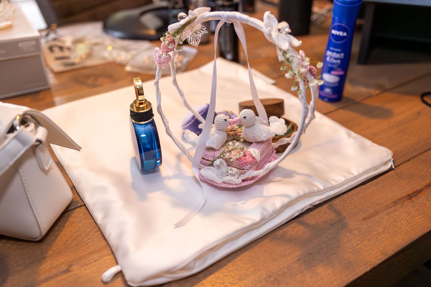 Wedding accessories and jewelry arranged on a wooden table.