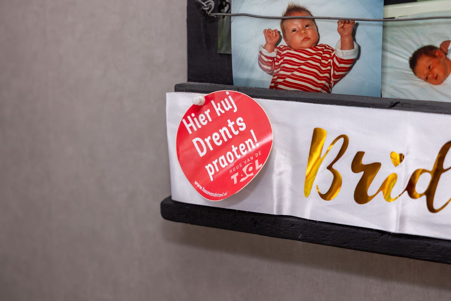 Close-up of photo display with red circular sticker and gold text.
