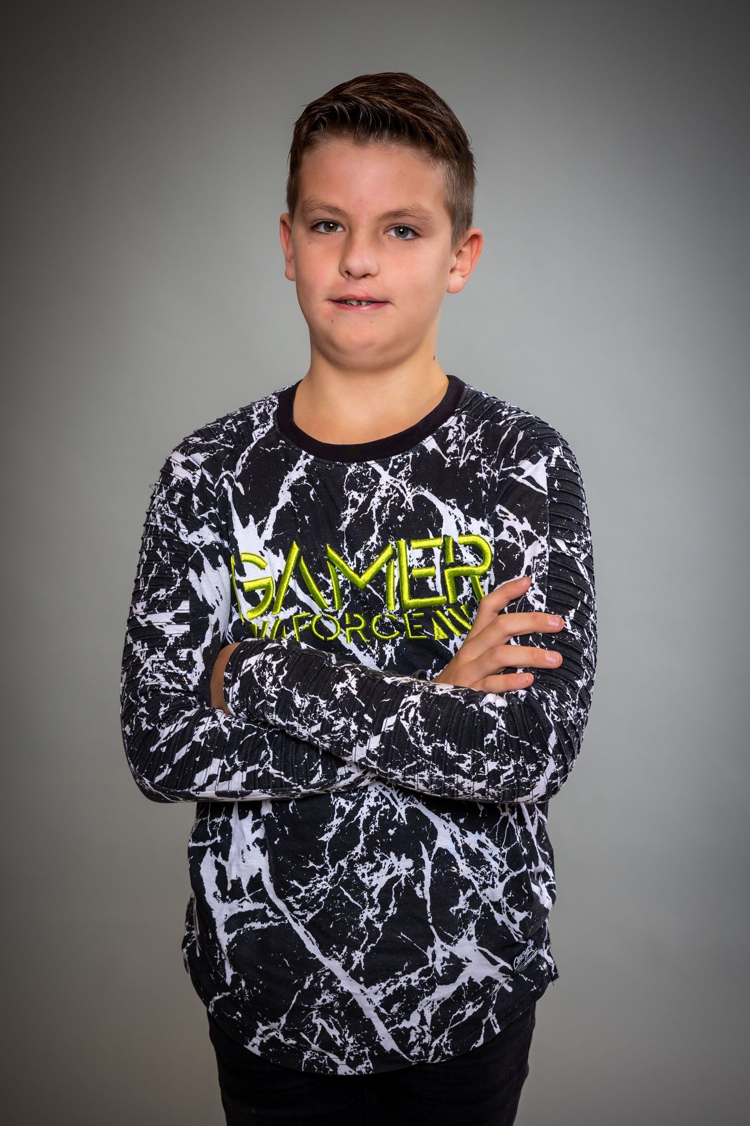 Young person wearing black and white marble patterned sweatshirt with neon green text in three different poses.