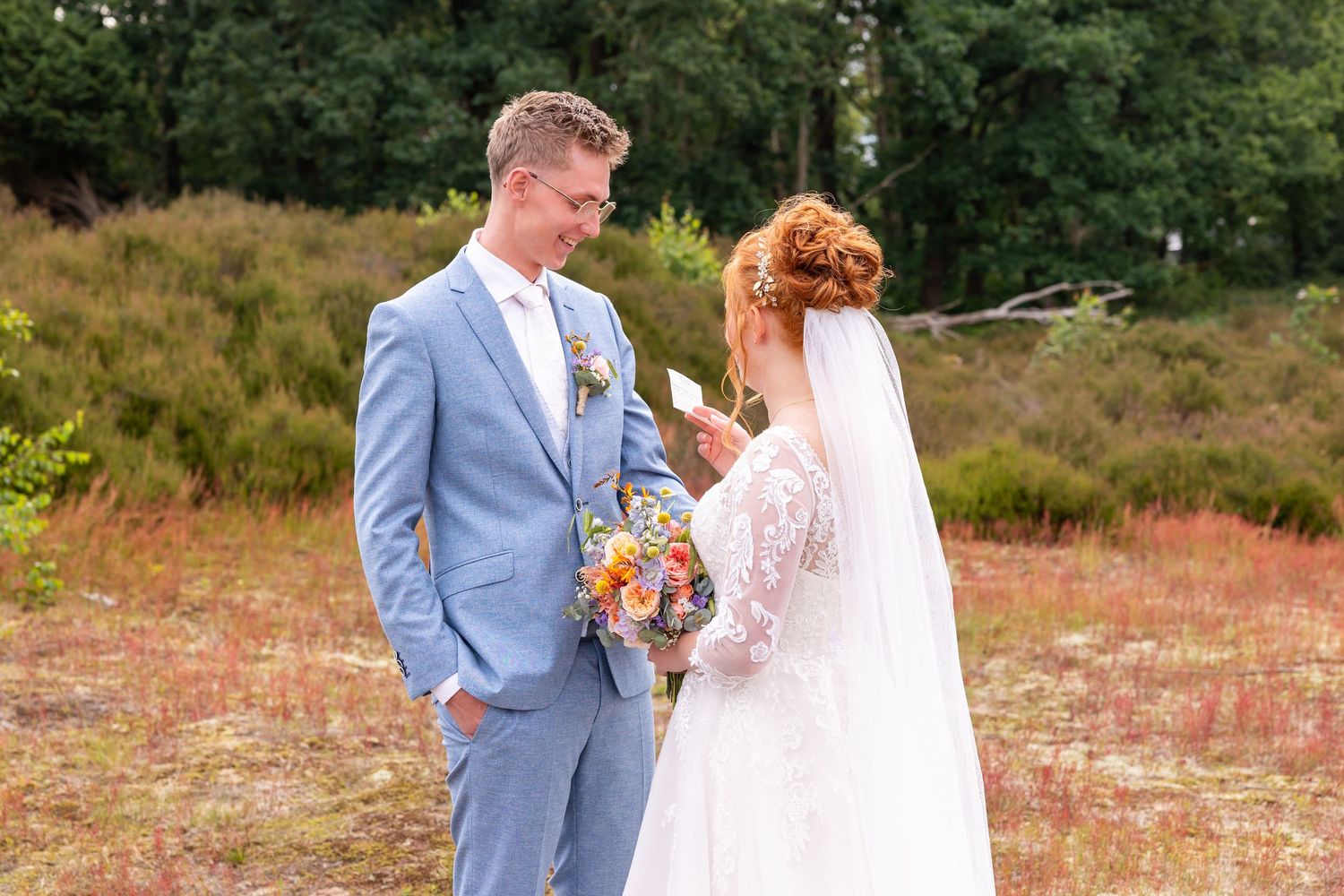 A wedding couple sharing a moment in an outdoor setting with natural heather backdrop.