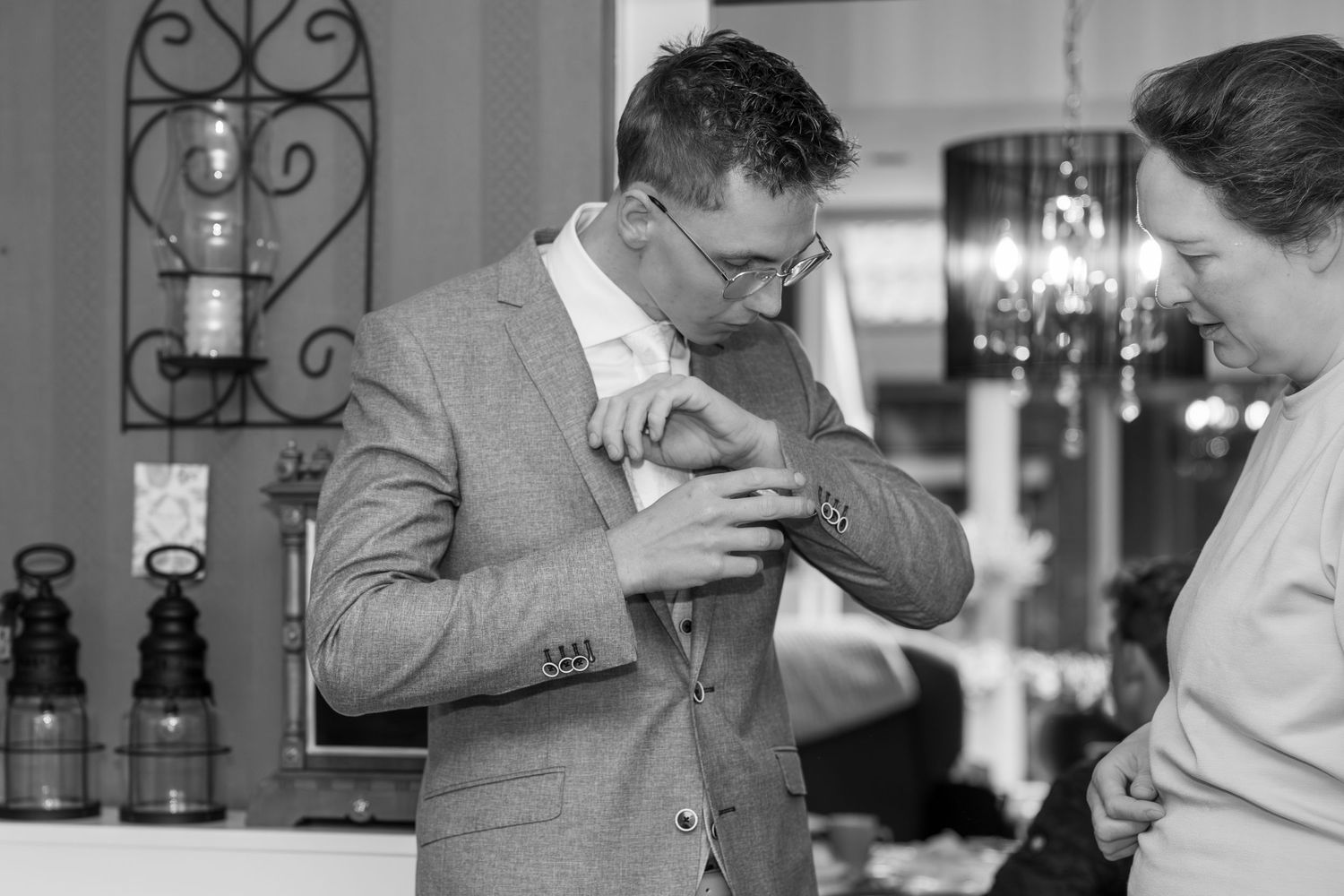 Person adjusting formal attire in black and white photograph.
