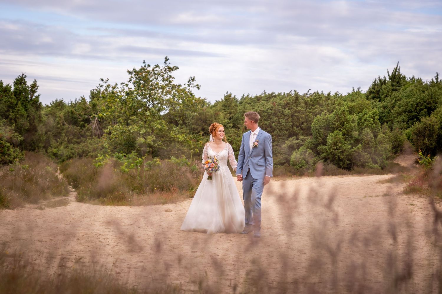 Wedding couple walking together in a scenic natural outdoor setting at sunset.