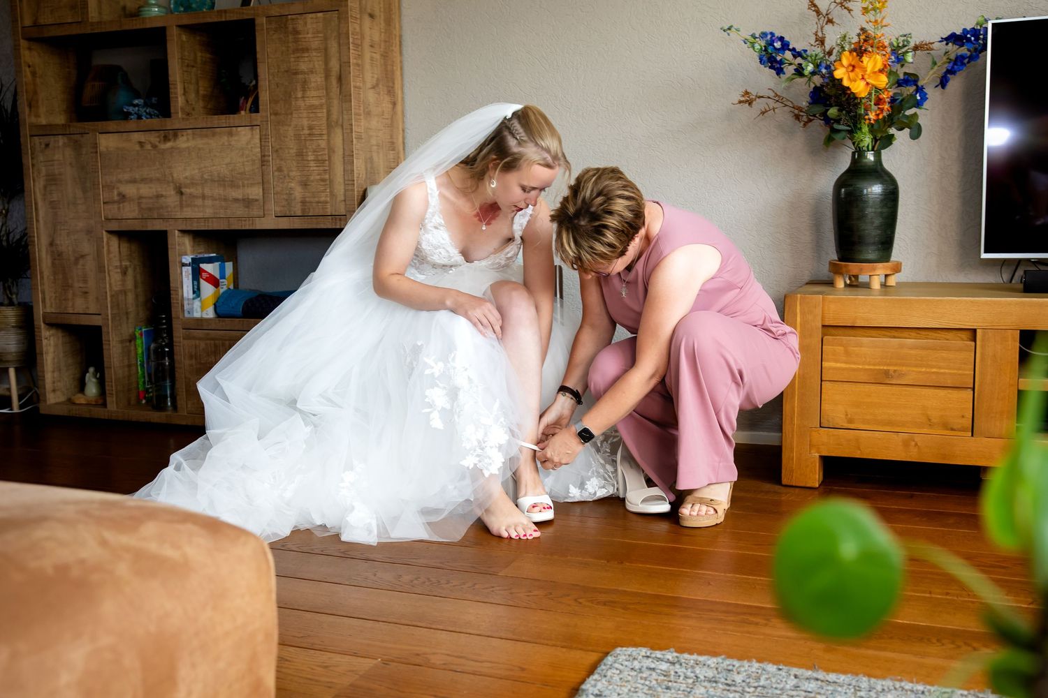 Activiteiten op de trouwdag vastgelegd in een woonkamer met houten meubilair en groene ballonaccenten.