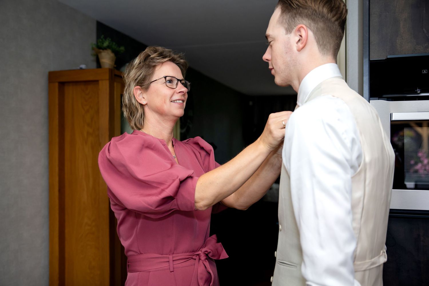 moeder sluit bloes bruidegom