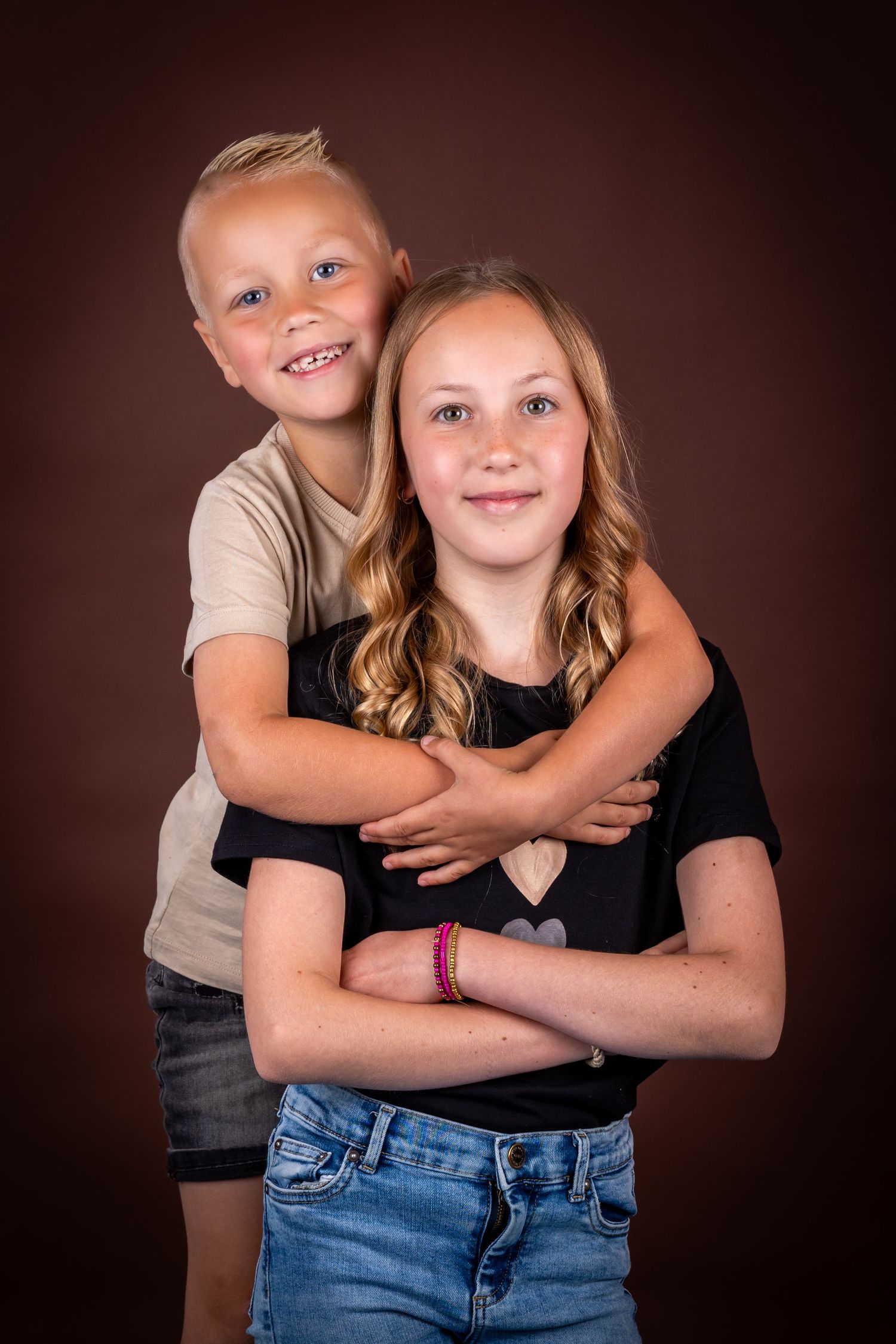A series of intimate sibling portraits against a dark background showing playful embraces and genuine smiles.