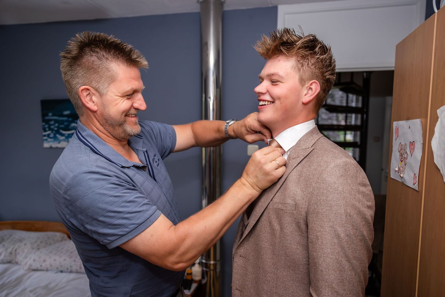 Two people getting ready in formal attire before an event.