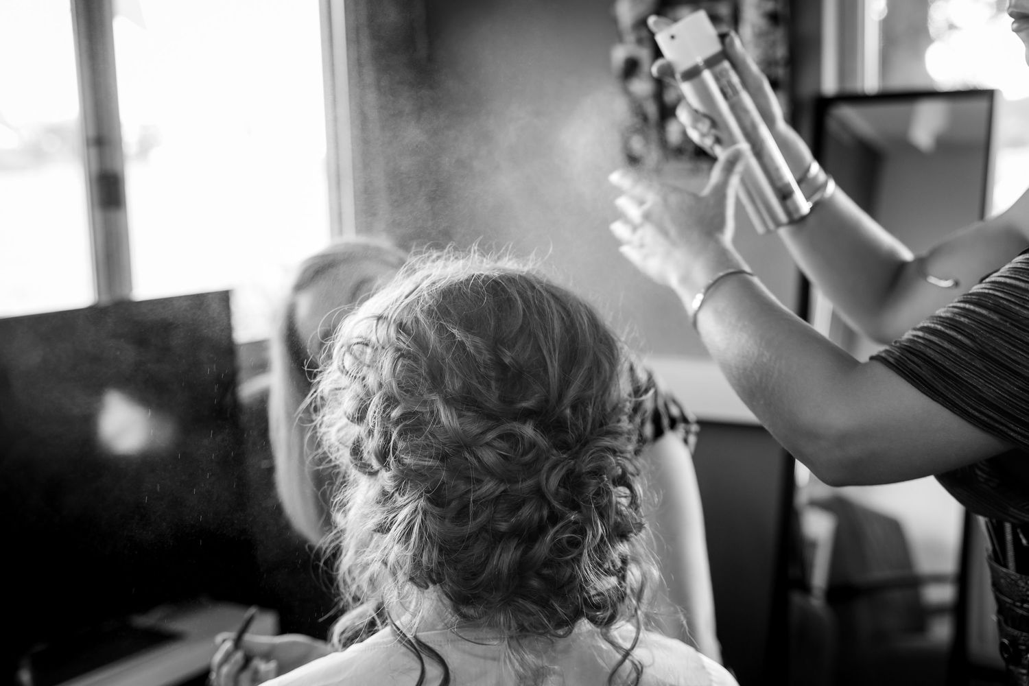 Getting ready scene with hair styling in black and white.