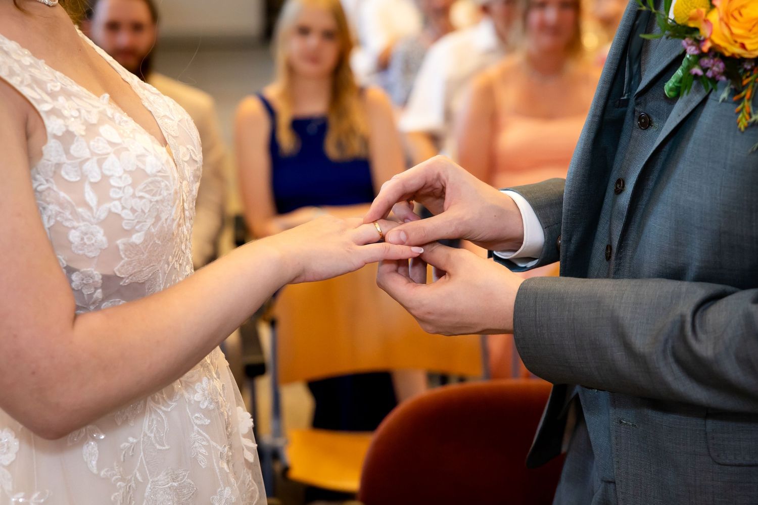Close-up shots of hands exchanging wedding rings during the ceremony.