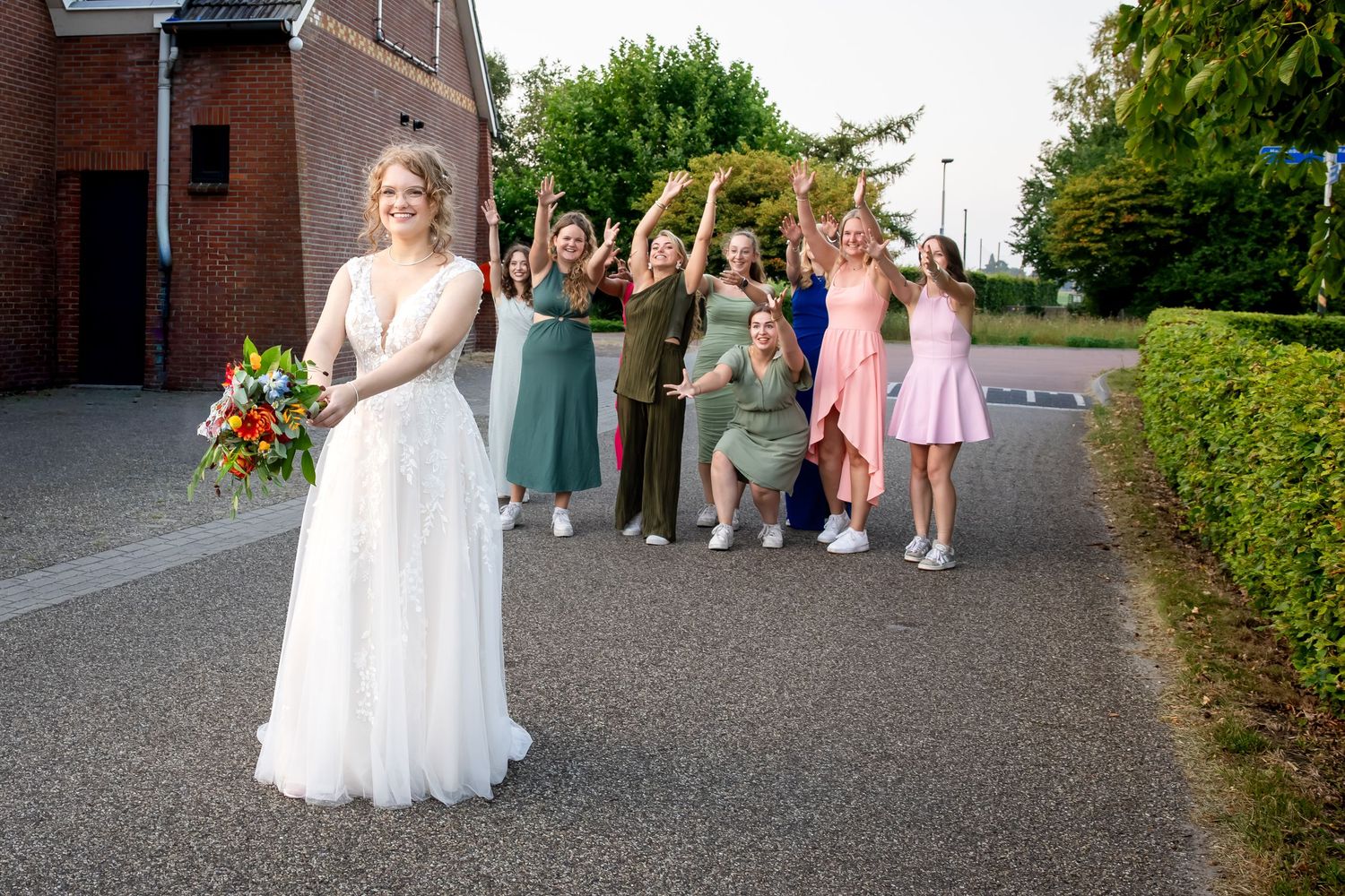 Guests form a receiving line outside the church on a sunny wedding day.
