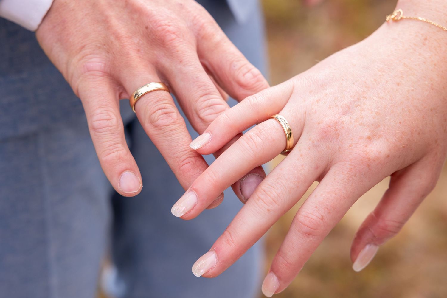 Close-up of newlyweds' hands showing their wedding rings.