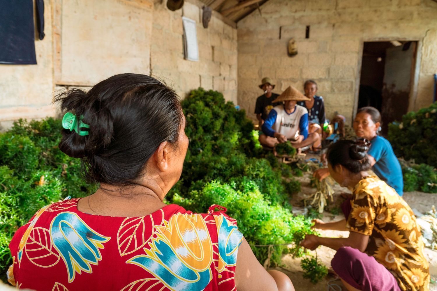 Community gathering sharing a meal in a traditional Indonesian home.