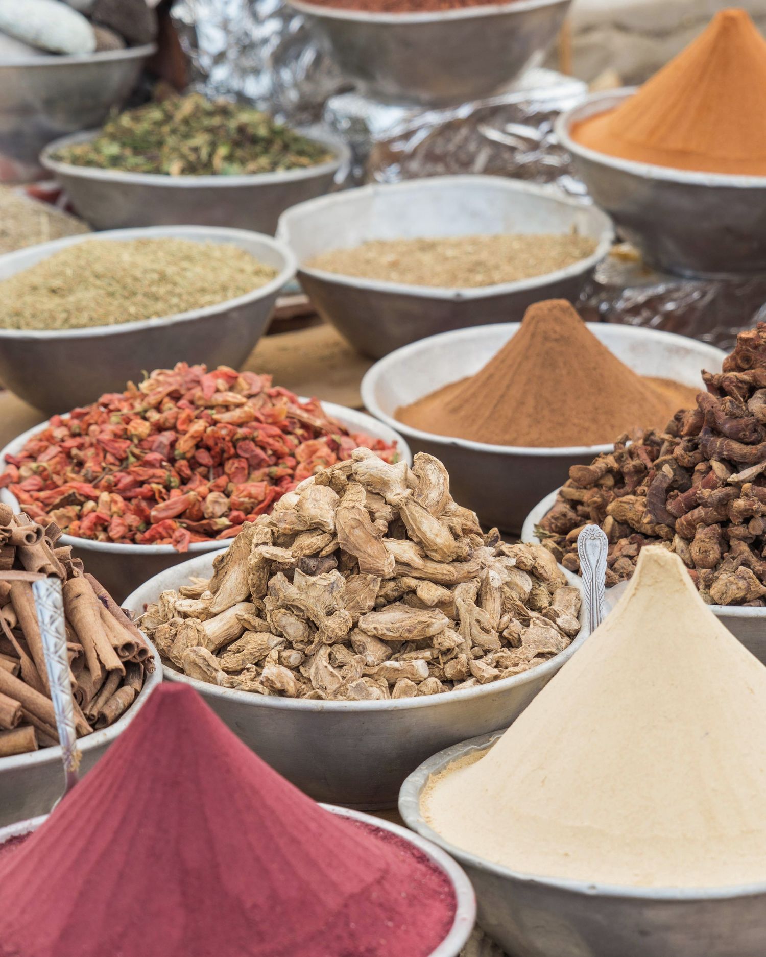 Various aromatic spices and seasonings displayed in bowls at Middle Eastern market.