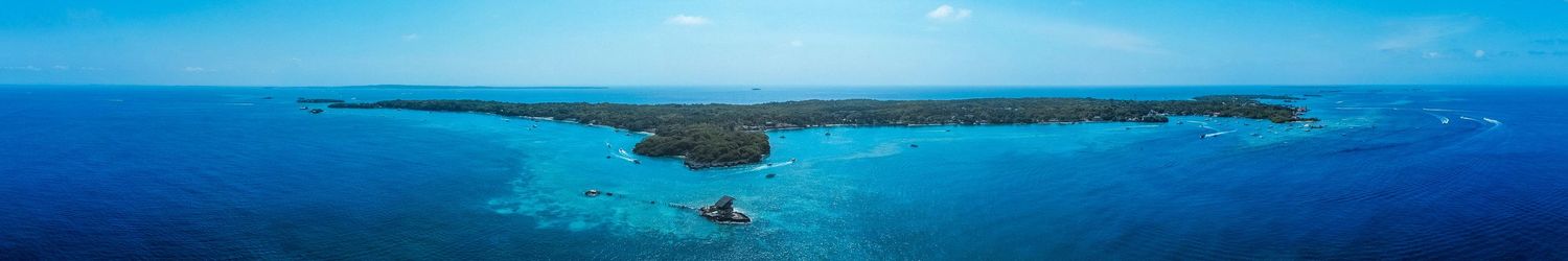 Wide panoramic view of a tropical coastline with islands dotting the horizon.