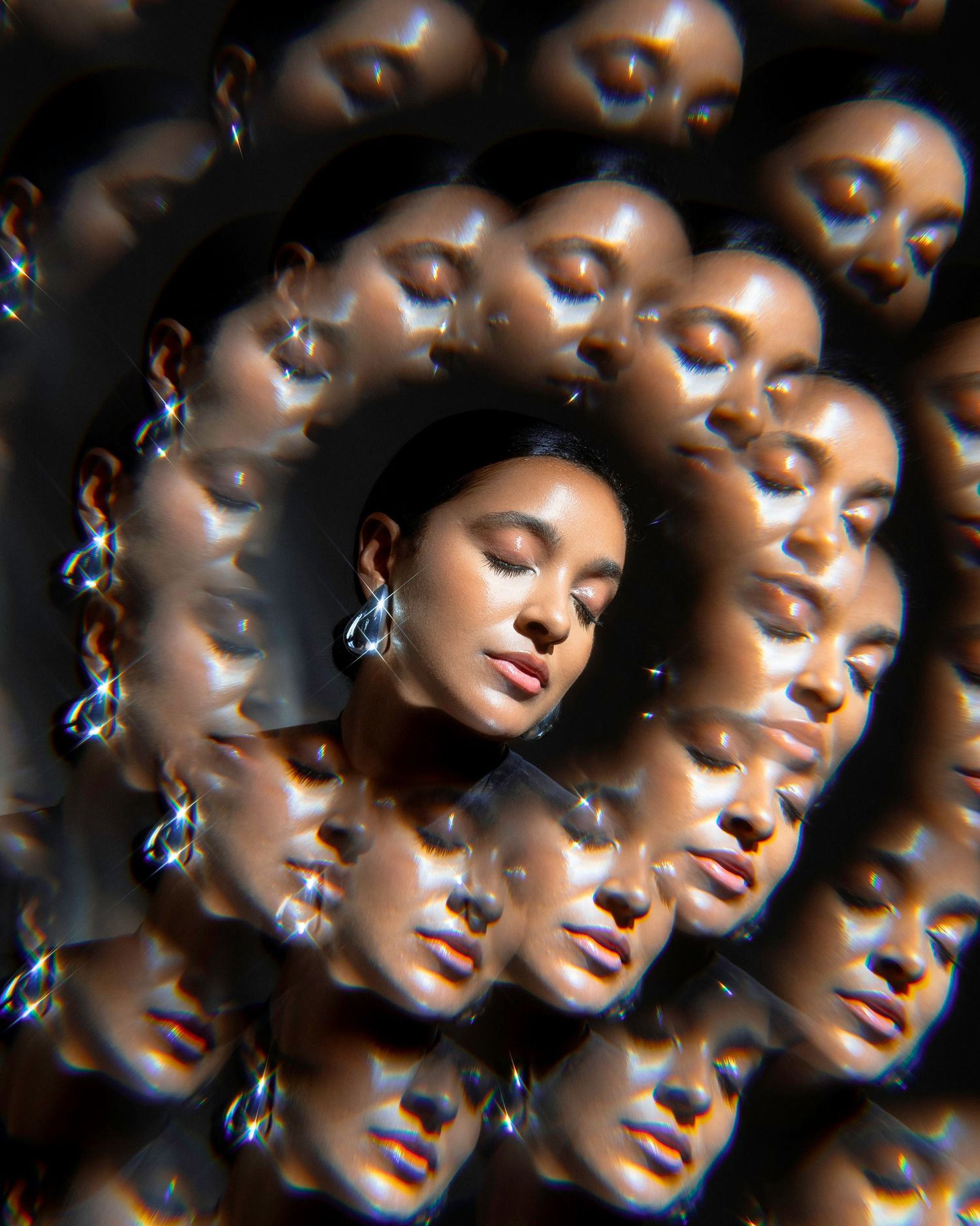 Creative kaleidoscope portrait effect with repeating reflections and sparkling jewelry.