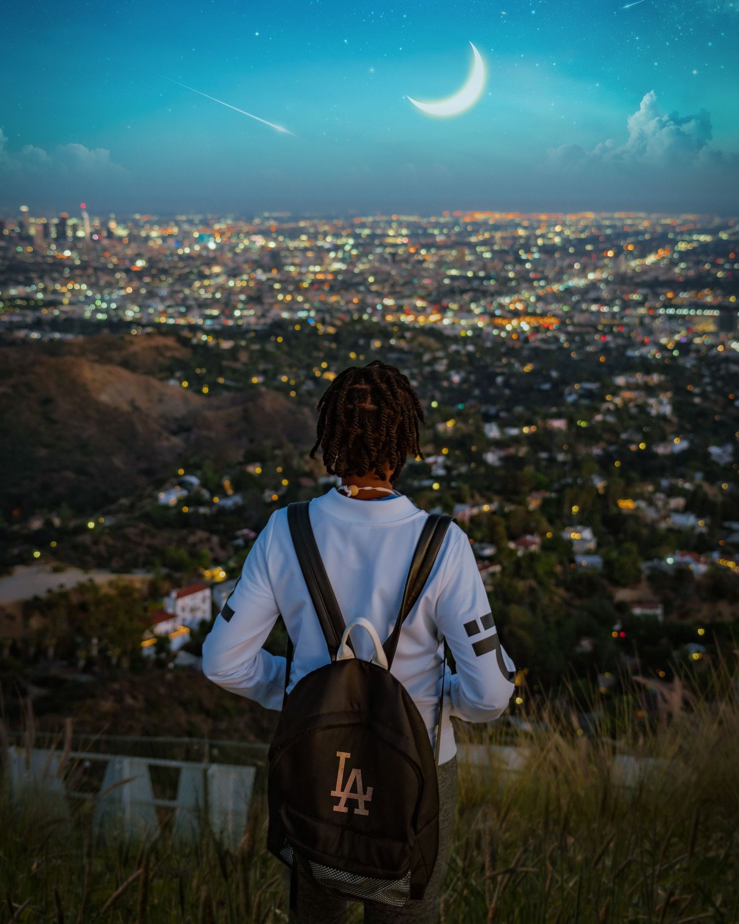 Scenic cityscape overlook at night with crescent moon and shooting star in turquoise sky.
