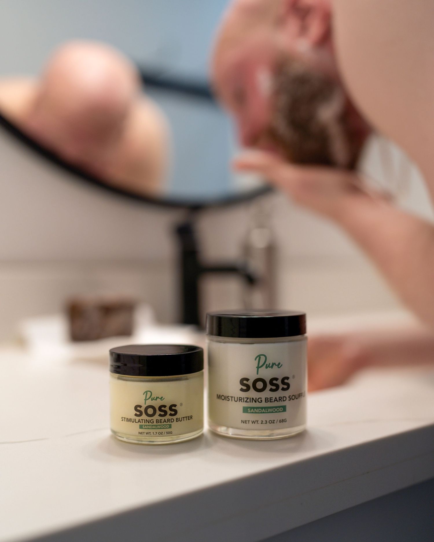 Two jars of SOSS skincare products on white bathroom counter with faucet.