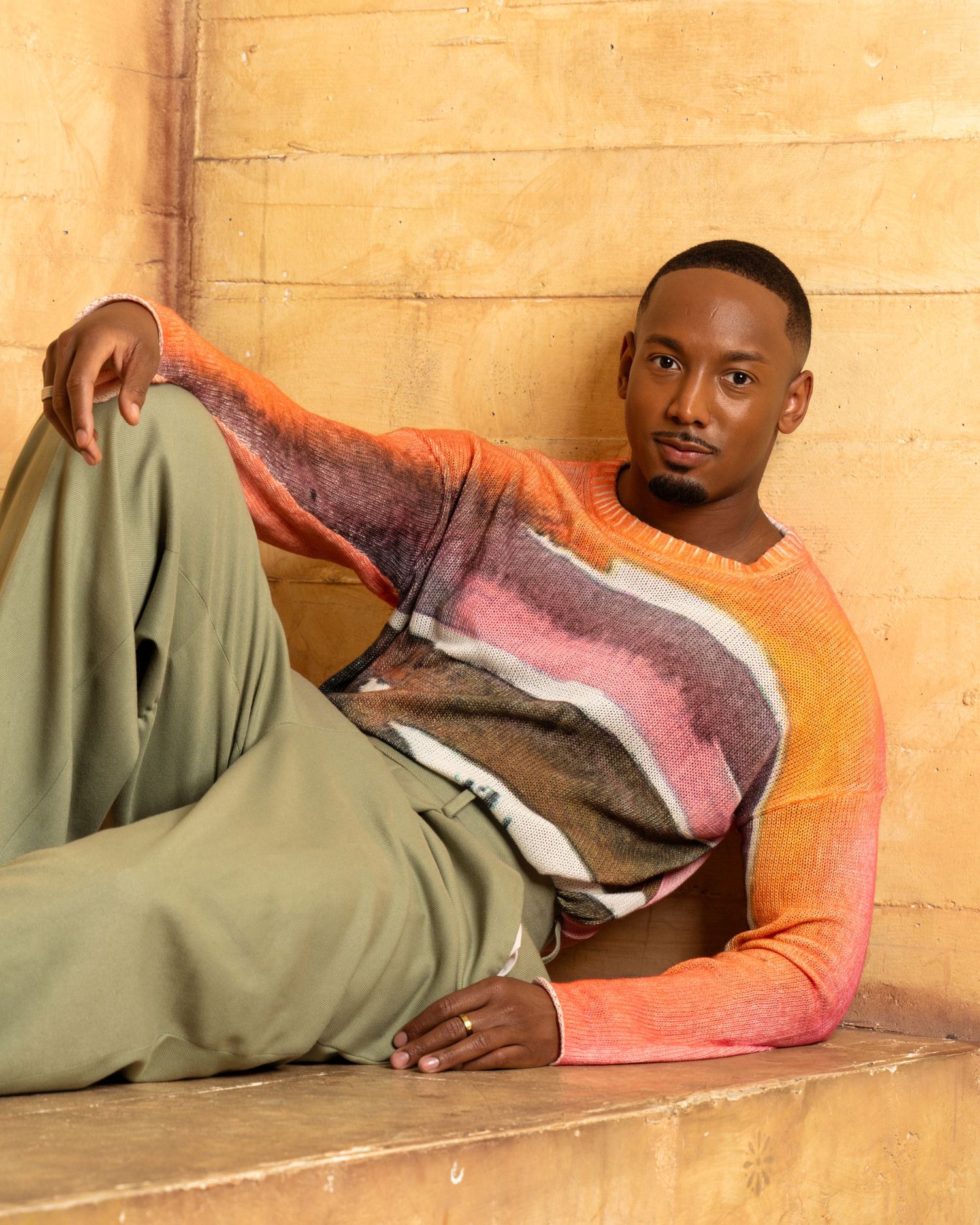 A person resting comfortably on a beige couch in a casual lounging position.