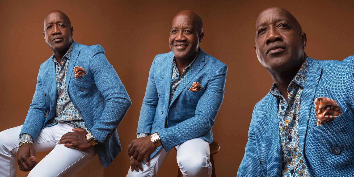 Professional headshots of men wearing light blue suits against brown background.