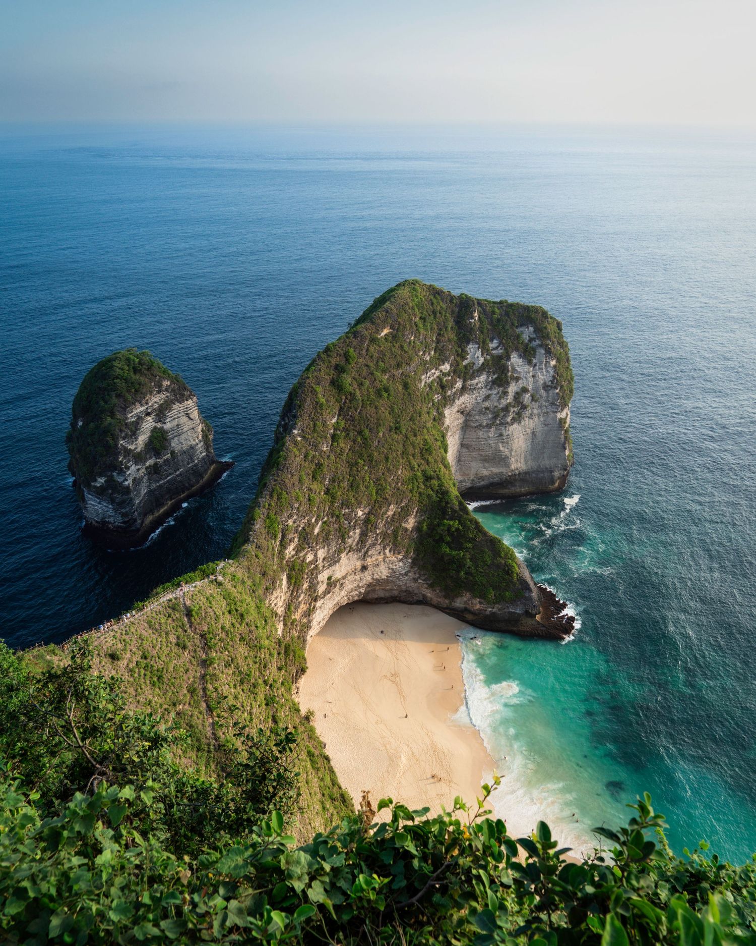 Stunning aerial view of Kelingking Beach in Nusa Penida, Indonesia with turquoise waters and limestone cliffs.