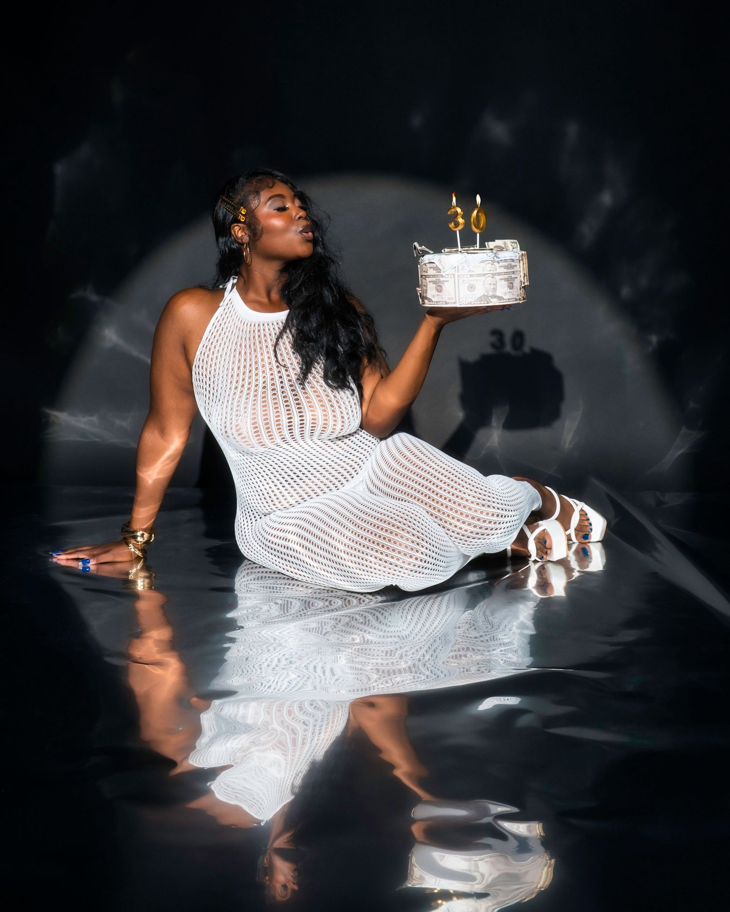 A dancer in a flowing white dress poses gracefully against a dark background in a dramatic photoshoot series.