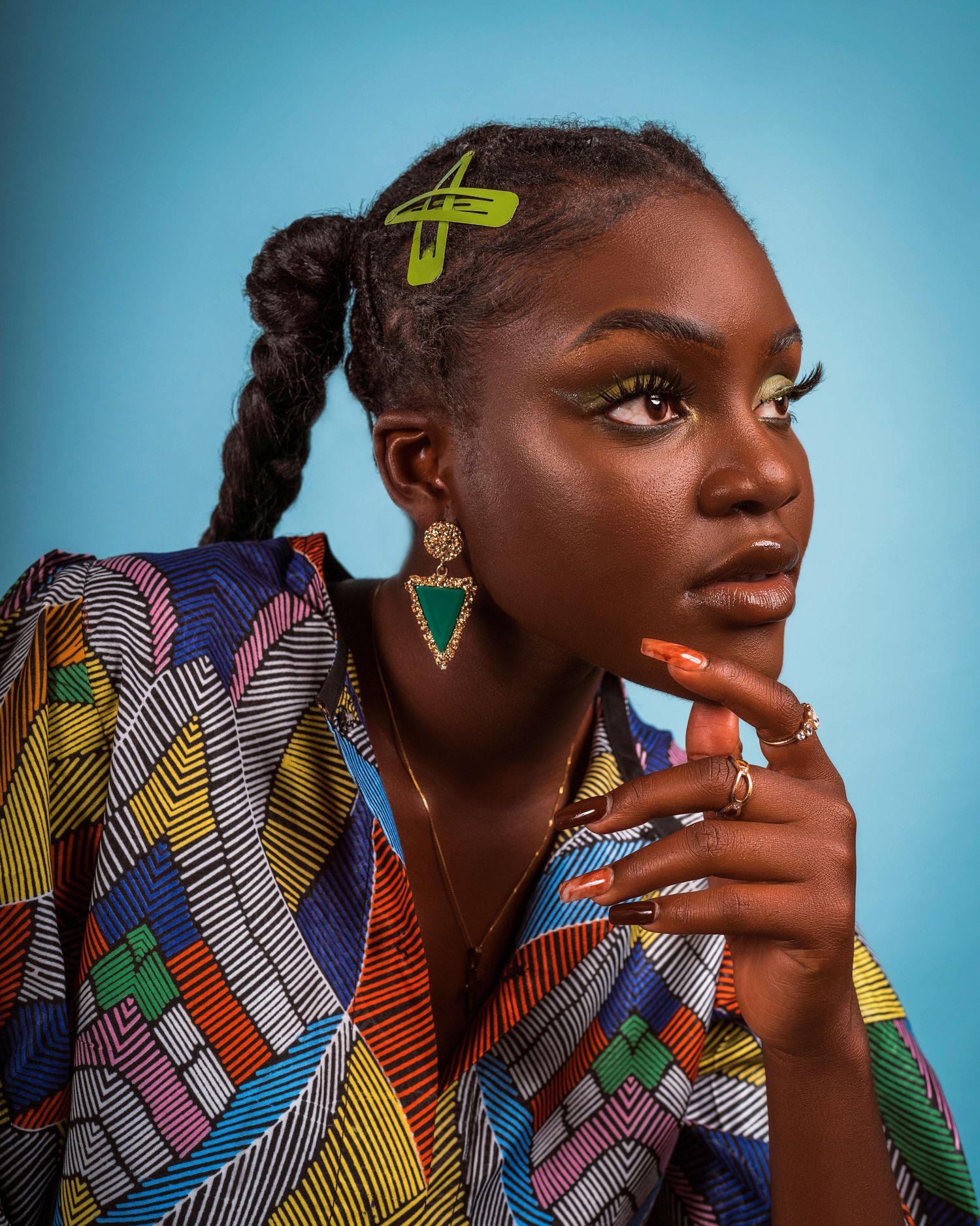 Beauty portrait in colorful geometric print with yellow hair clip and statement earrings.