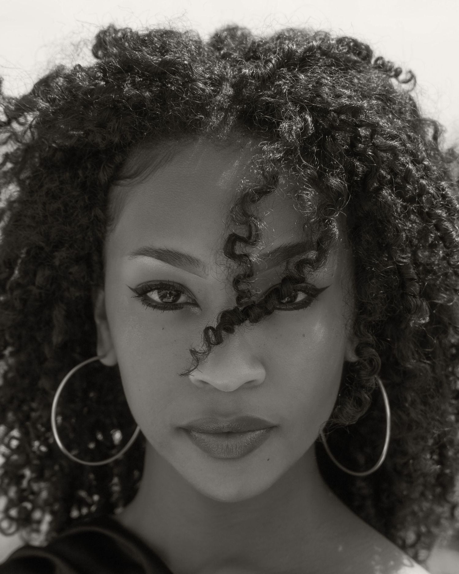 Black and white portraits featuring natural curly hair and hoop earrings.